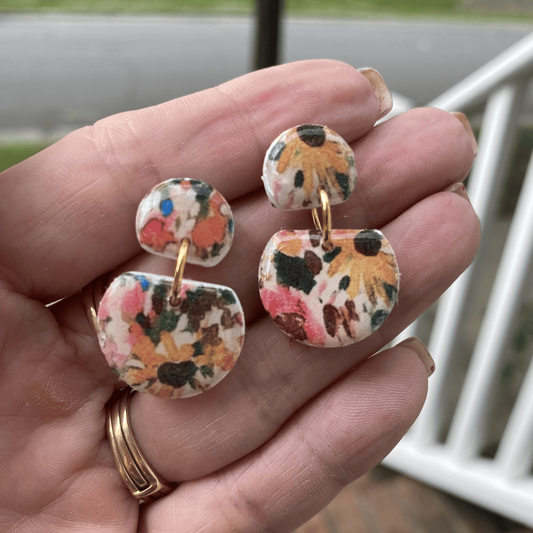 Close-up of floral dangle polymer clay earrings held in hand, handcrafted in Charlotte NC