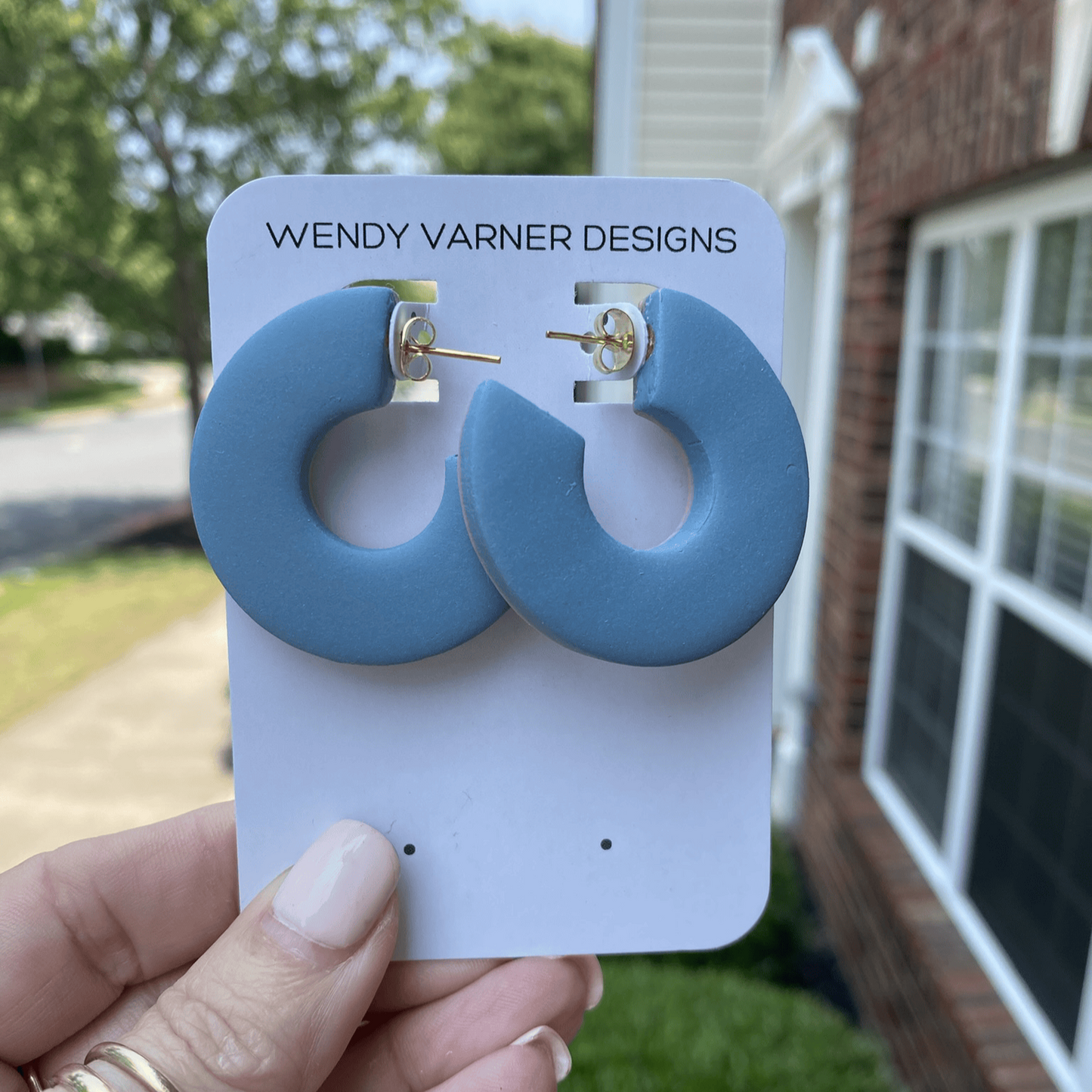 Round blue statement earrings made from polymer clay on earring card