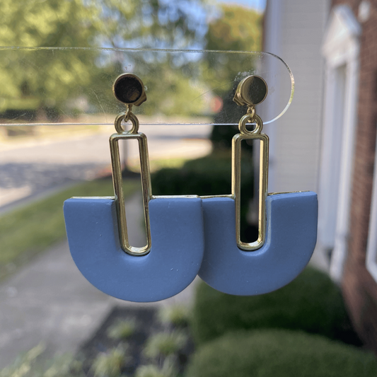 Steel blue handmade earrings photographed hanging in natural daylight
