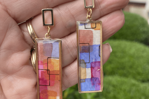  Flat lay of colorful handmade polymer clay earrings from Wendy Varner Designs on sale, displayed on a neutral background