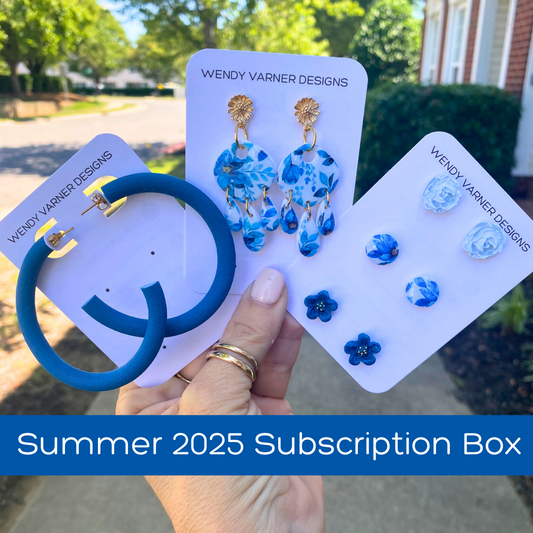 Summer 2025 Seasons Change polymer clay subscription box with blue hoops, blue floral dangles and blue stud earrings