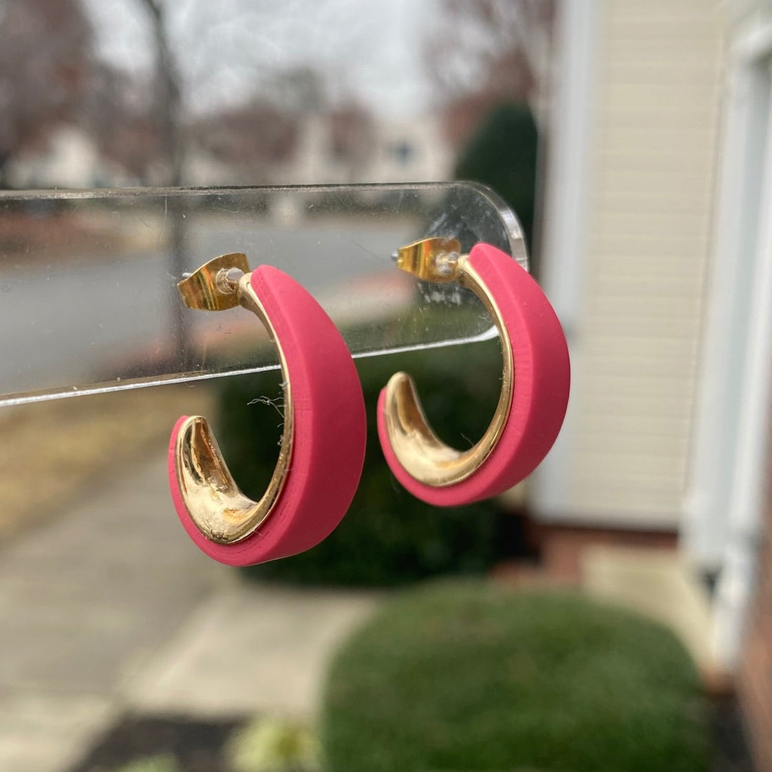 Blush pink and gold polymer clay hoop earrings displayed outdoors on clear stand, handmade by Wendy Varner Designs 