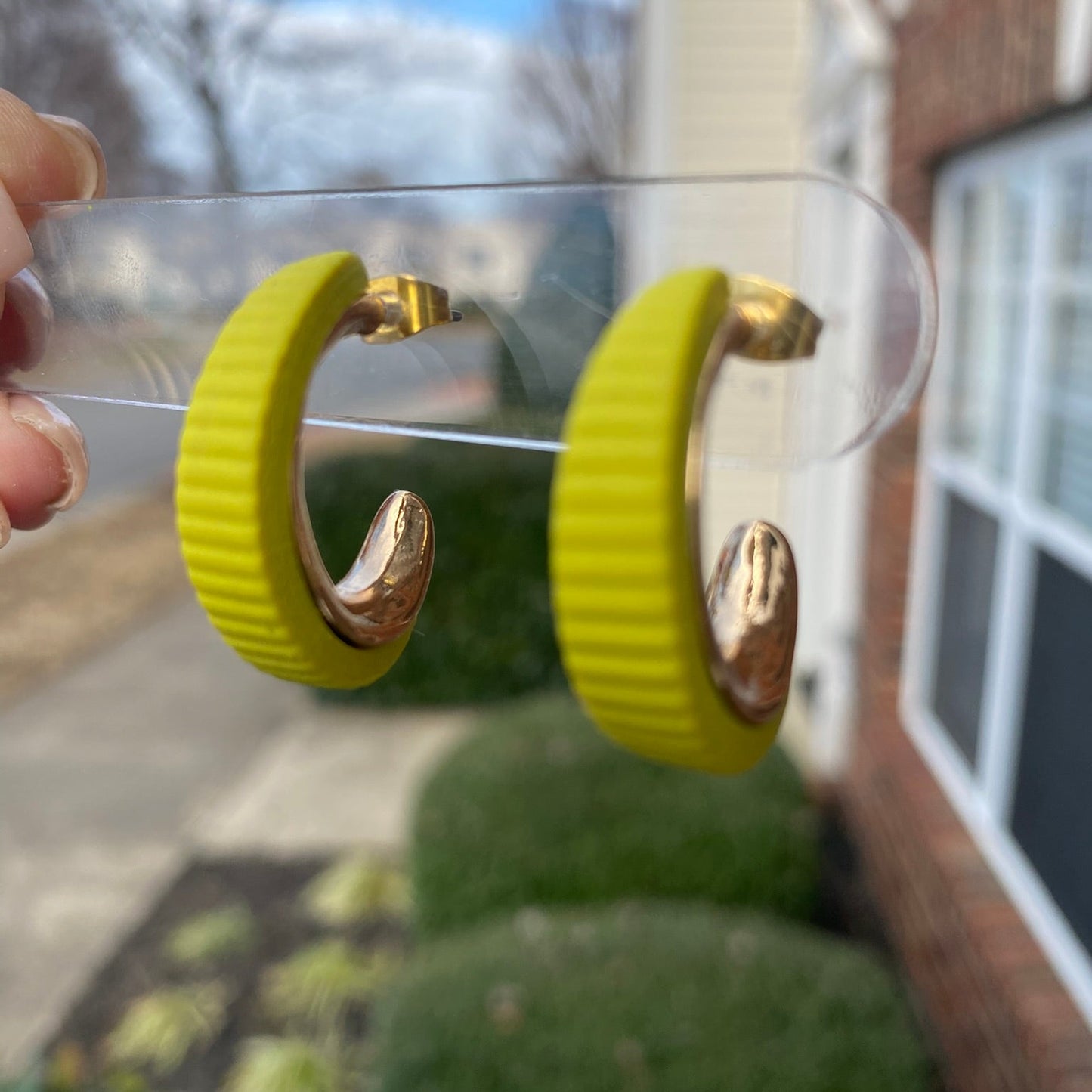 Side angle of citron green and gold textured polymer clay hoop earrings