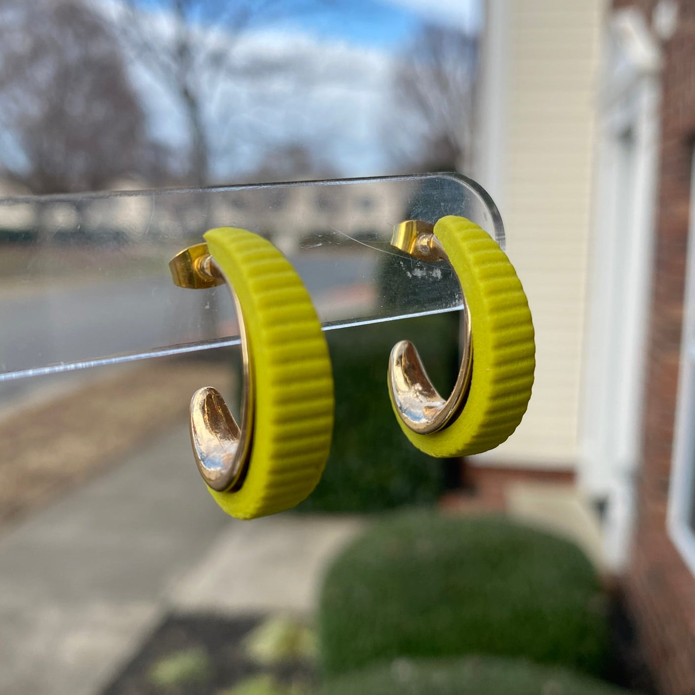 Close-up photo of citron green polymer clay hoops with gold inner curve, lightweight handmade earrings