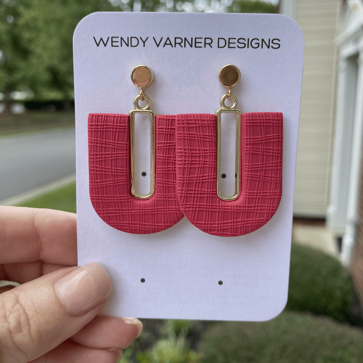 Close-up of dark strawberry red textured polymer clay arch earrings with gold-plated rectangle accents and gold posts, handmade by Wendy Varner Designs in Charlotte NC.