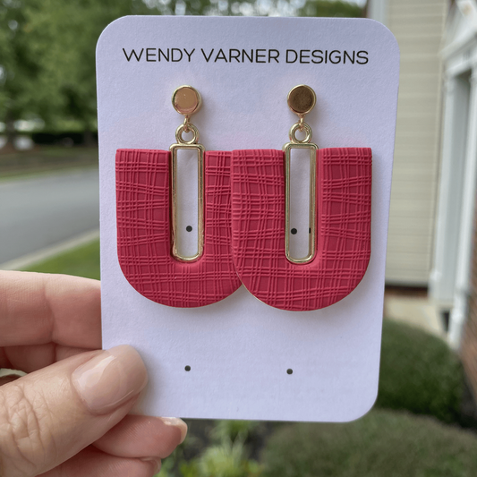 Close-up of dark strawberry red textured polymer clay arch earrings with gold-plated rectangle accents and gold posts, handmade by Wendy Varner Designs in Charlotte NC.