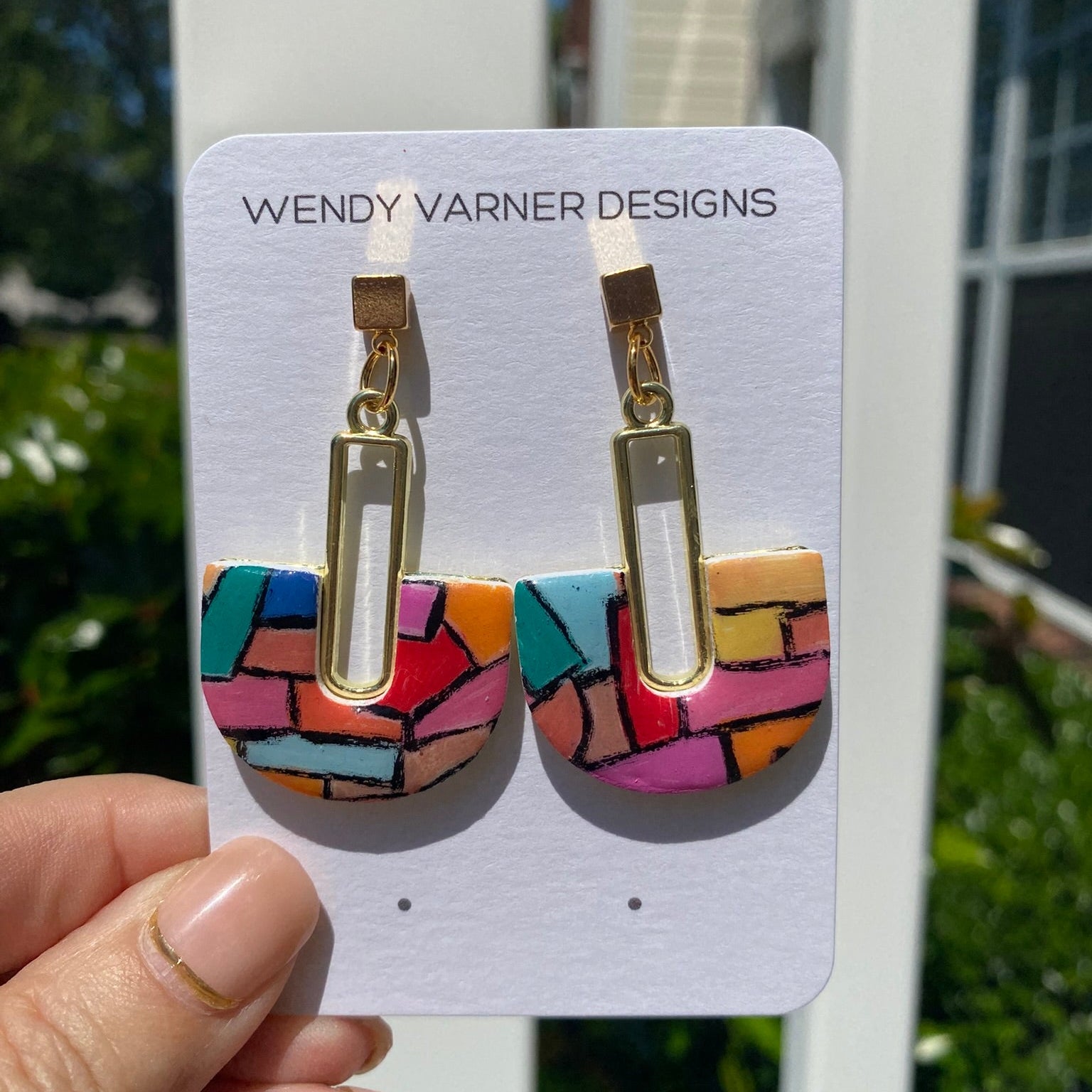 Hand-painted polymer clay stained glass mosaic arch dangle earrings with gold hardware on a Wendy Varner Designs earring card, handmade in Charlotte NC
