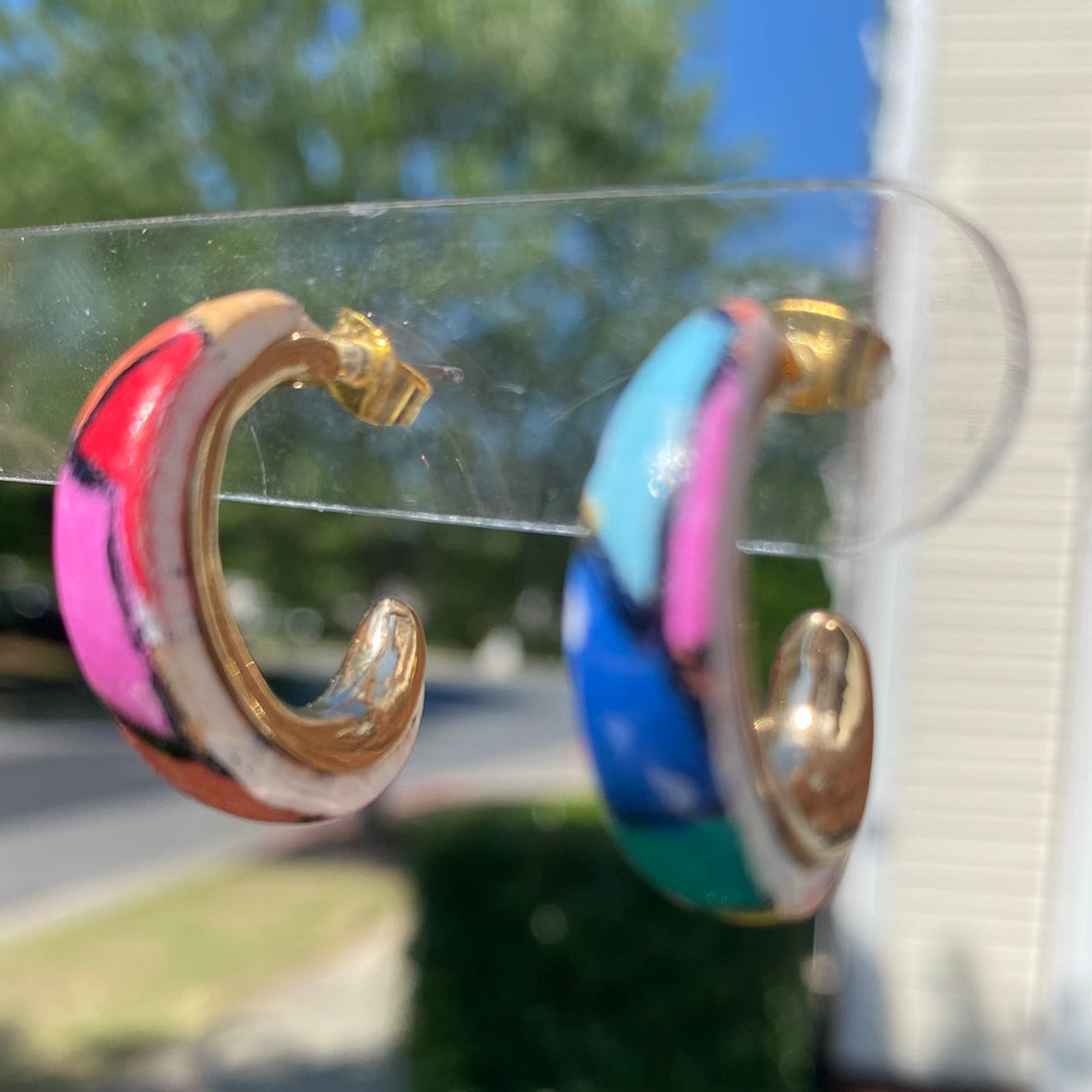 Hand-painted polymer clay stained glass mosaic hoop earrings held up showing pink, red, blue and teal multicolor pattern, handmade in Charlotte NC by Wendy Varner Designs