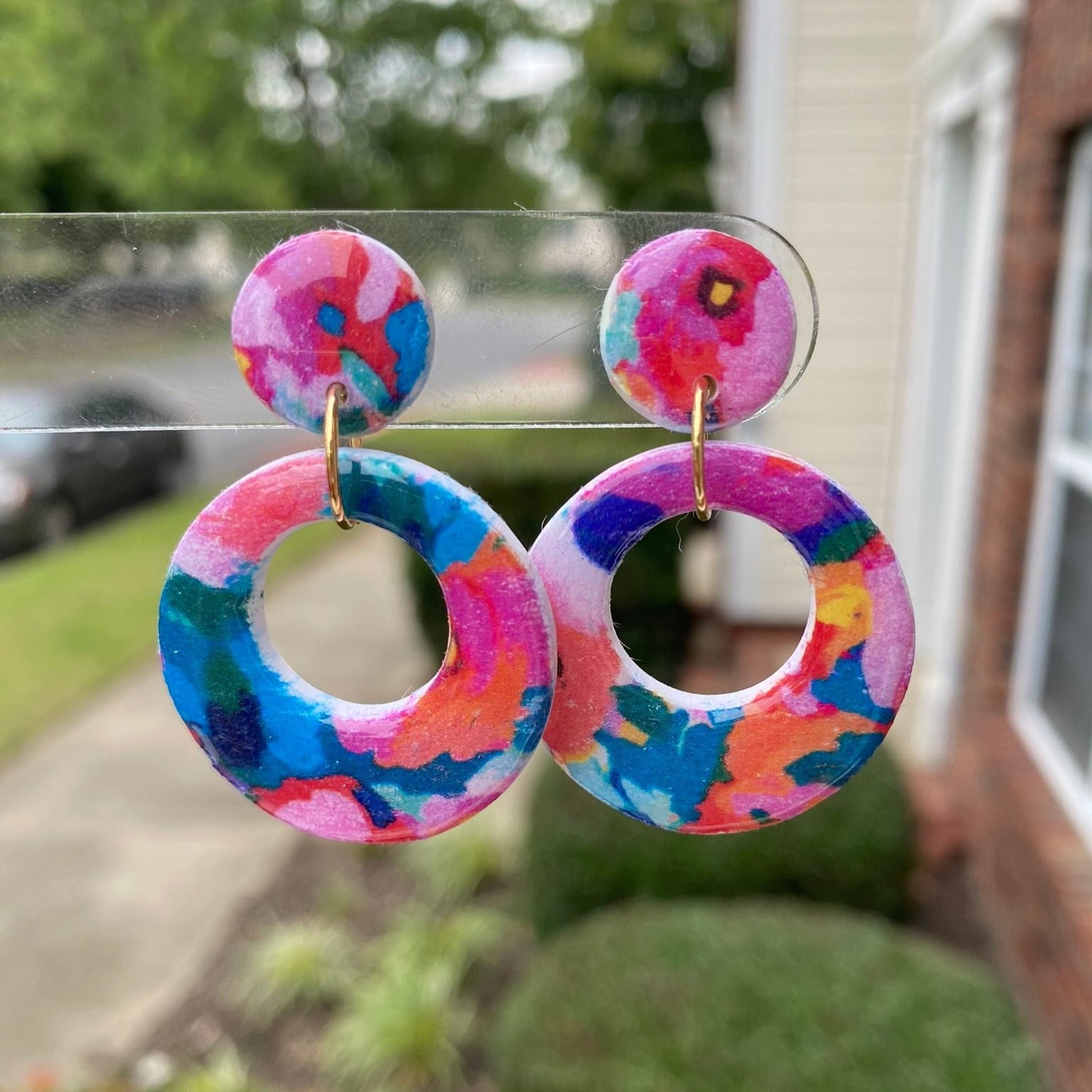 Round polymer clay earrings with colorful, abstract floral patterns in a circular cut-out design, from the Hawaiian Paradise collection.