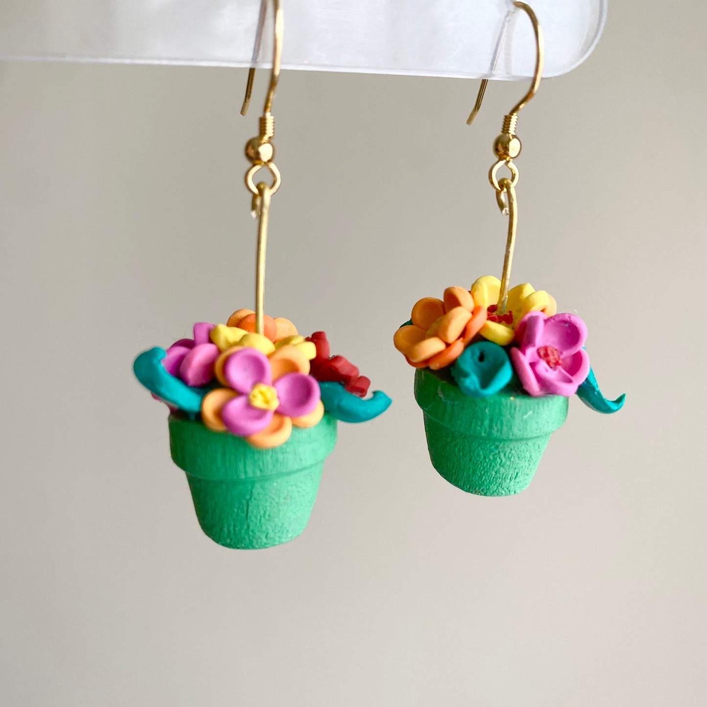 Hand-crafted polymer clay earrings shaped like green flower pots with colorful flowers, from the Hawaiian Paradise collection.