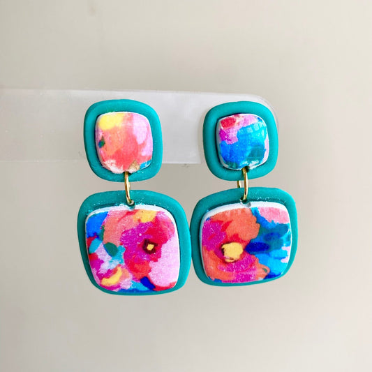 Square polymer clay earrings with vibrant, watercolor-style floral designs, accented with teal frames, from the Hawaiian Paradise collection.