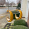 Mustard yellow and gold polymer clay hoop earrings displayed outdoors on clear stand, handmade by Wendy Varner Designs 