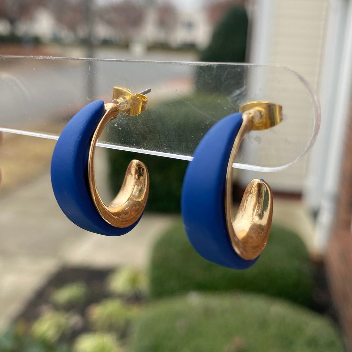 Side angle of navy blue and gold textured polymer clay hoop earrings