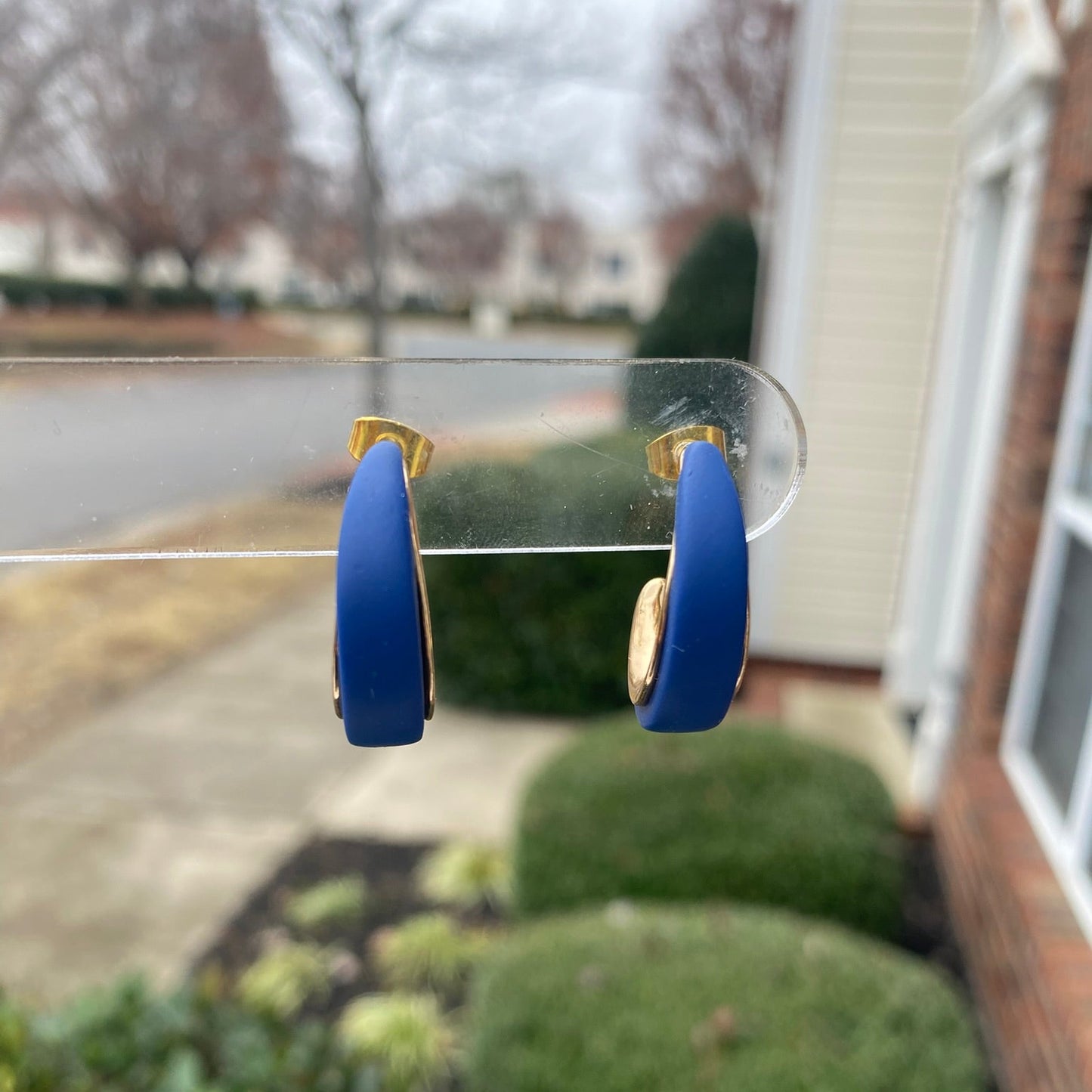 Close-up photo of navy blue polymer clay hoops with gold inner curve, lightweight handmade earrings