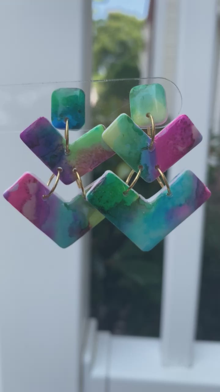 Bolt polymer clay earrings with vibrant teal, pink, green, and purple geometric shapes from The Brush Stroke collection