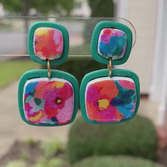 Square polymer clay earrings with vibrant, watercolor-style floral designs, accented with teal frames, from the Hawaiian Paradise collection.