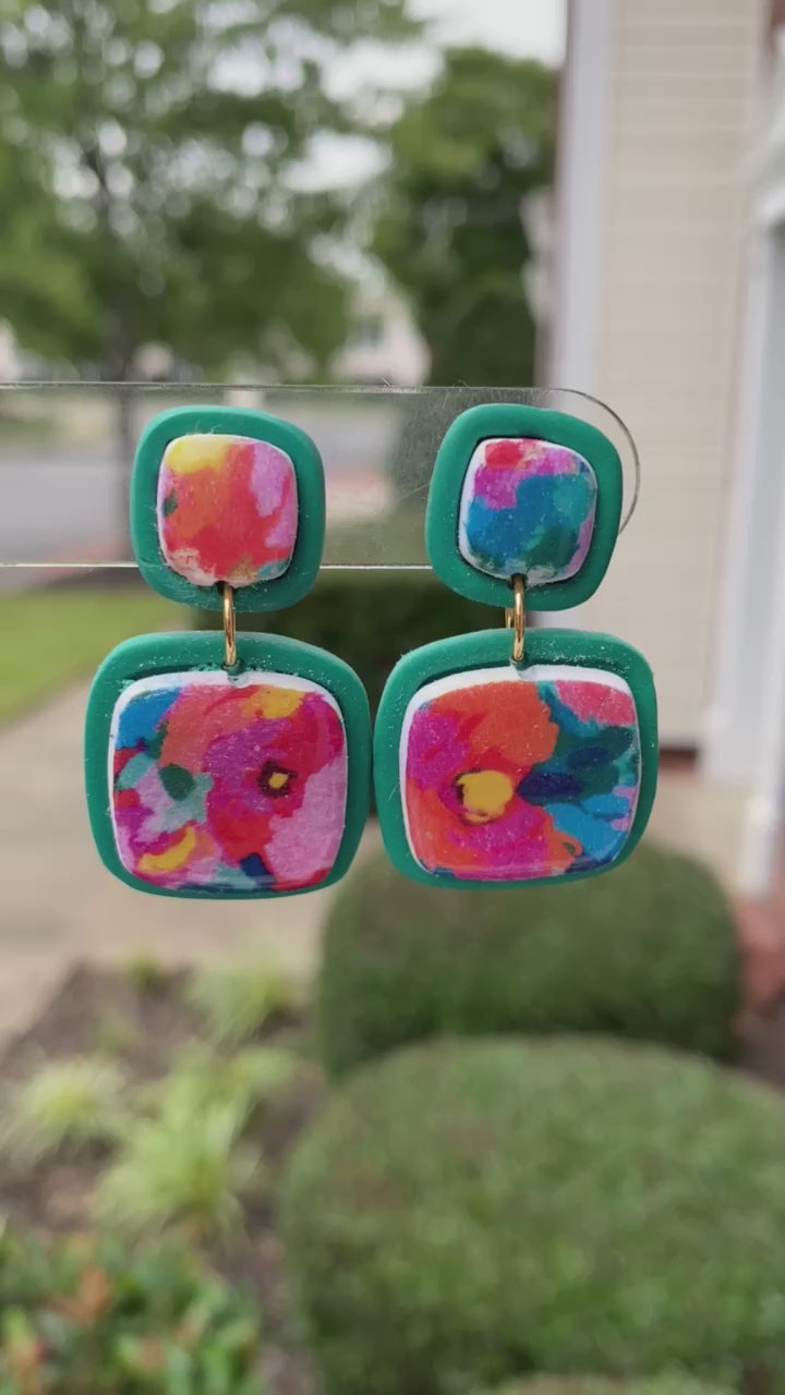 Square polymer clay earrings with vibrant, watercolor-style floral designs, accented with teal frames, from the Hawaiian Paradise collection.