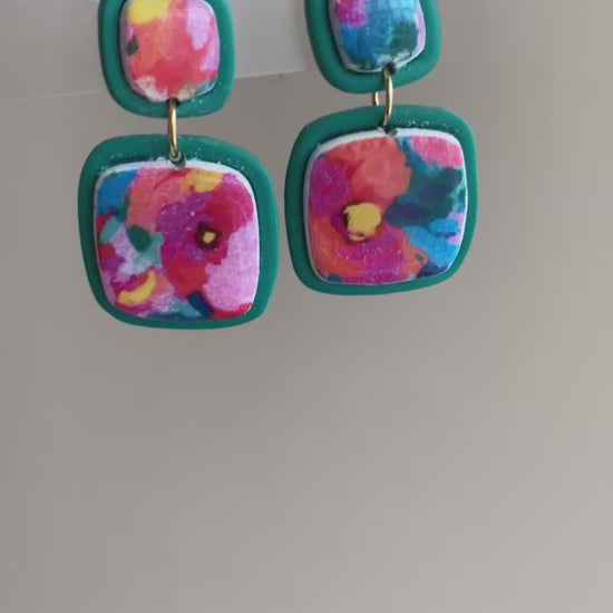 Square polymer clay earrings with vibrant, watercolor-style floral designs, accented with teal frames, from the Hawaiian Paradise collection.