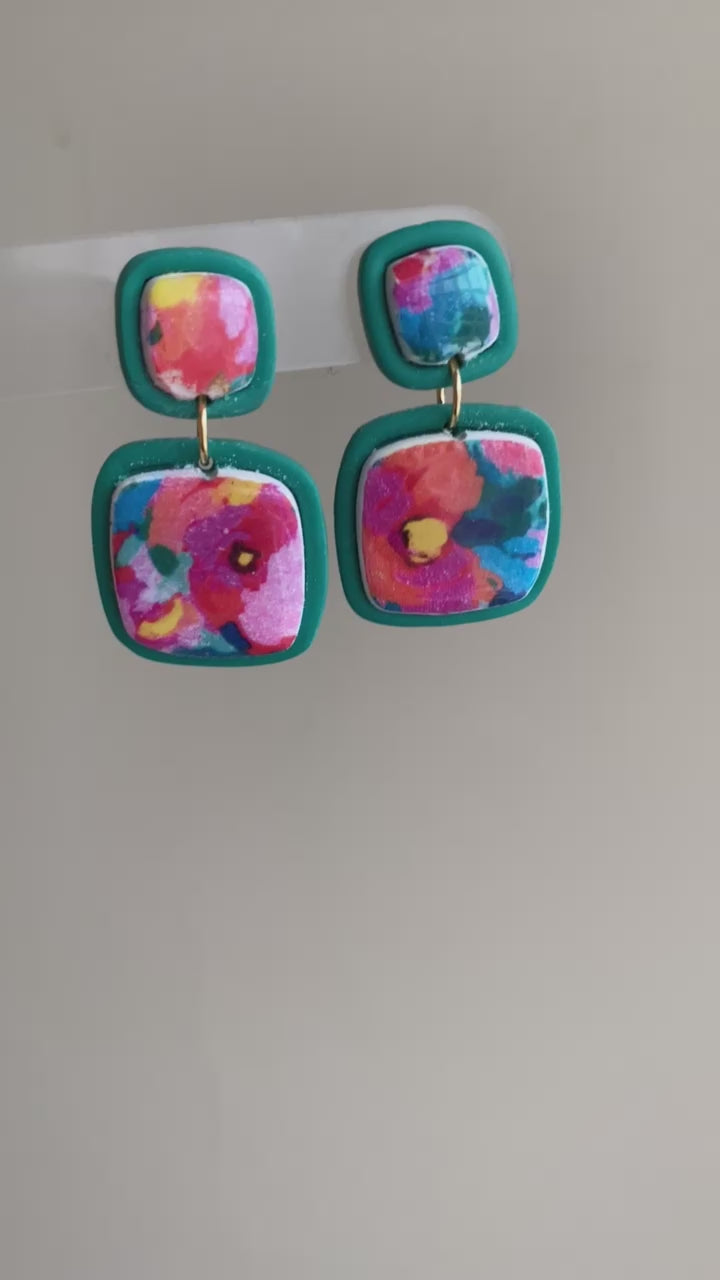 Square polymer clay earrings with vibrant, watercolor-style floral designs, accented with teal frames, from the Hawaiian Paradise collection.