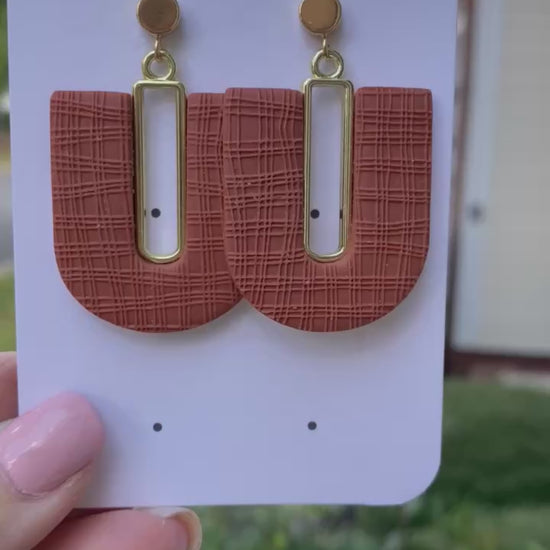 Polymer clay terra cotta arch earrings displayed outdoors in hand by Wendy Varner Designs