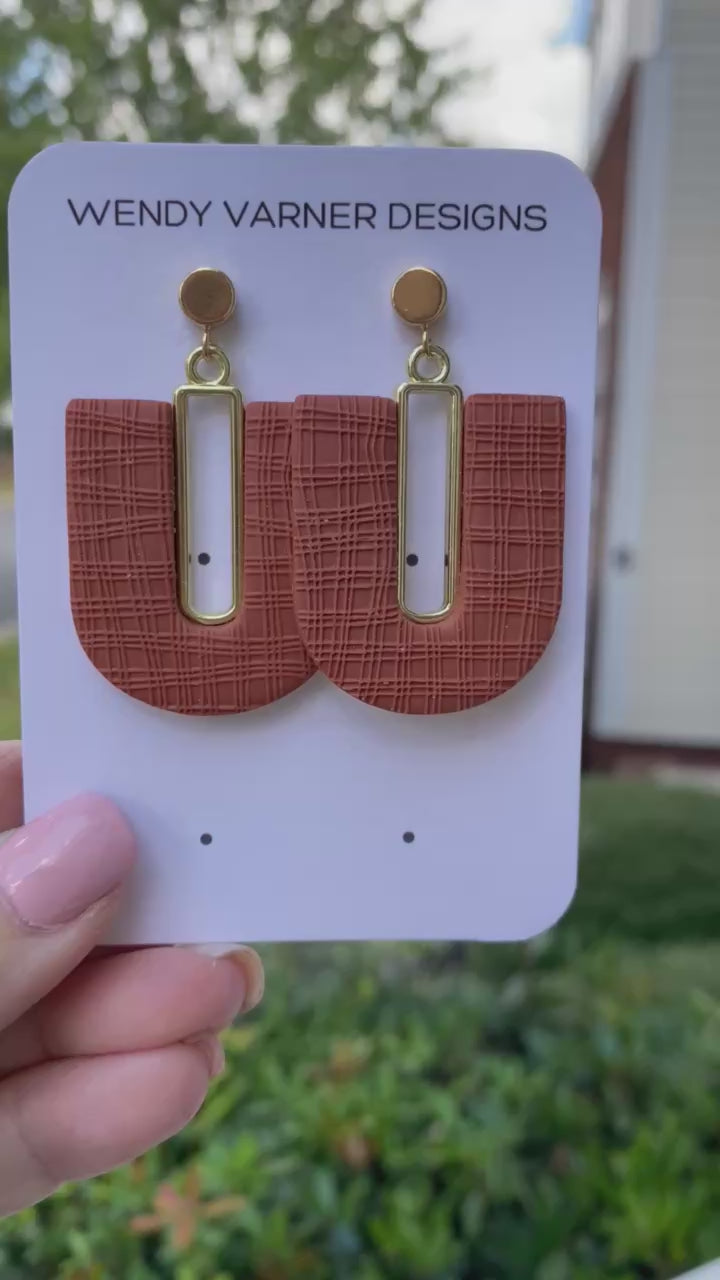 Polymer clay terra cotta arch earrings displayed outdoors in hand by Wendy Varner Designs