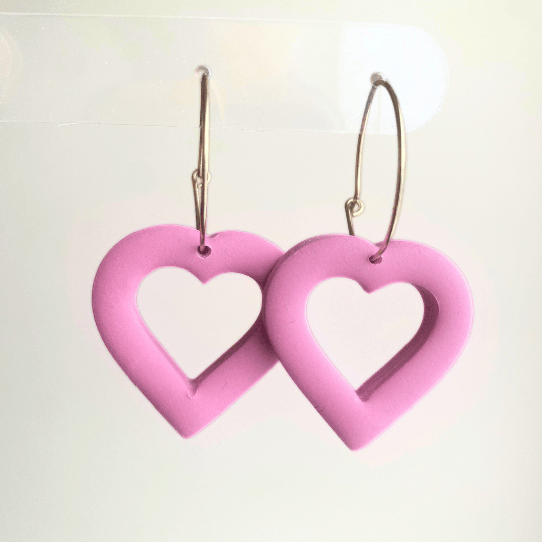 Handmade pink puffy heart dangle earrings made from lightweight polymer clay with gold-plated hoops