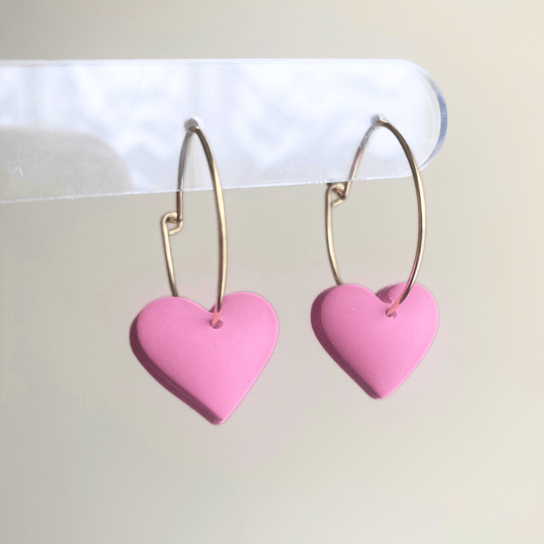 Handmade pink puffy heart dangle earrings made from lightweight polymer clay with gold-plated hoops