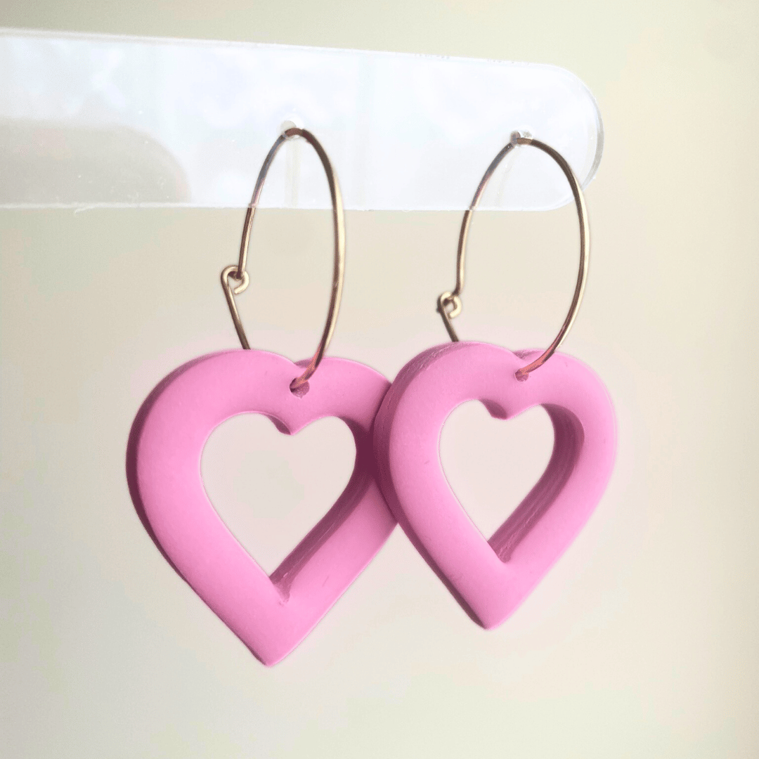 Handmade pink puffy heart dangle earrings made from lightweight polymer clay with gold-plated hoops