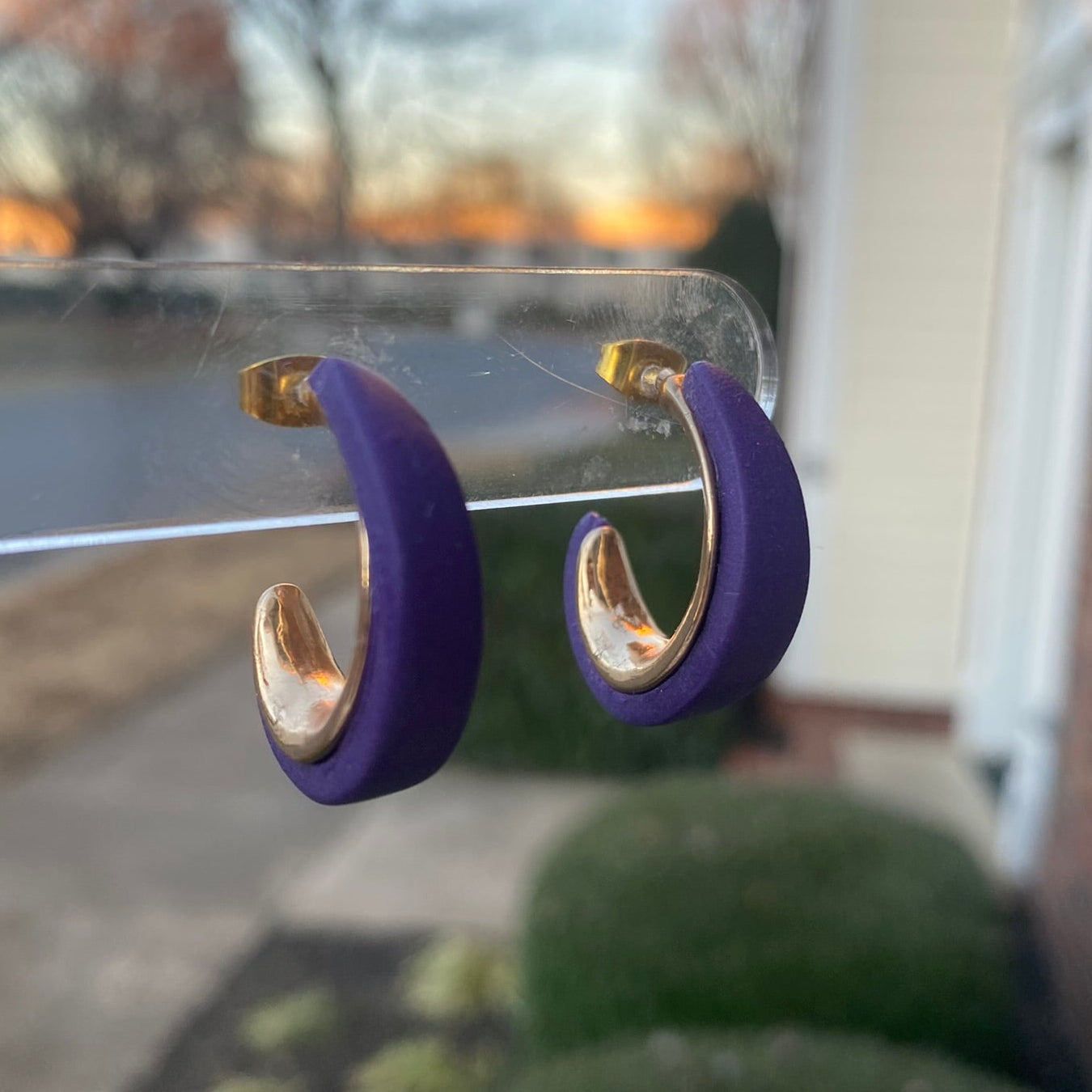 Close-up photo of purple polymer clay hoops with gold inner curve, lightweight handmade earrings