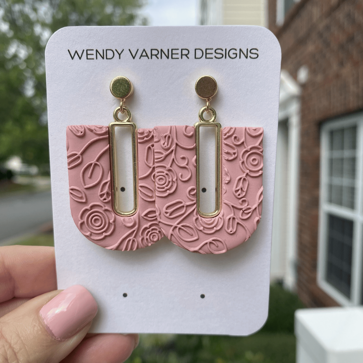Rose blush textured polymer clay arch earrings with gold-plated open rectangle accents, hanging display.