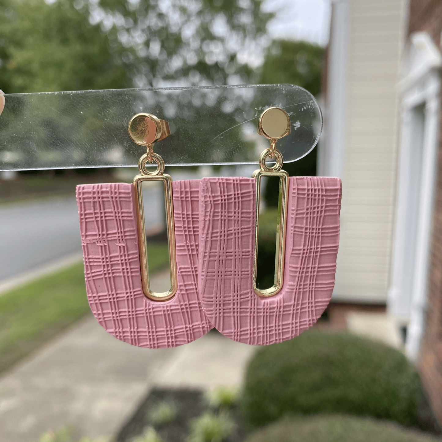 Rose blush textured polymer clay arch earrings with gold-plated open rectangle accents, hanging display.