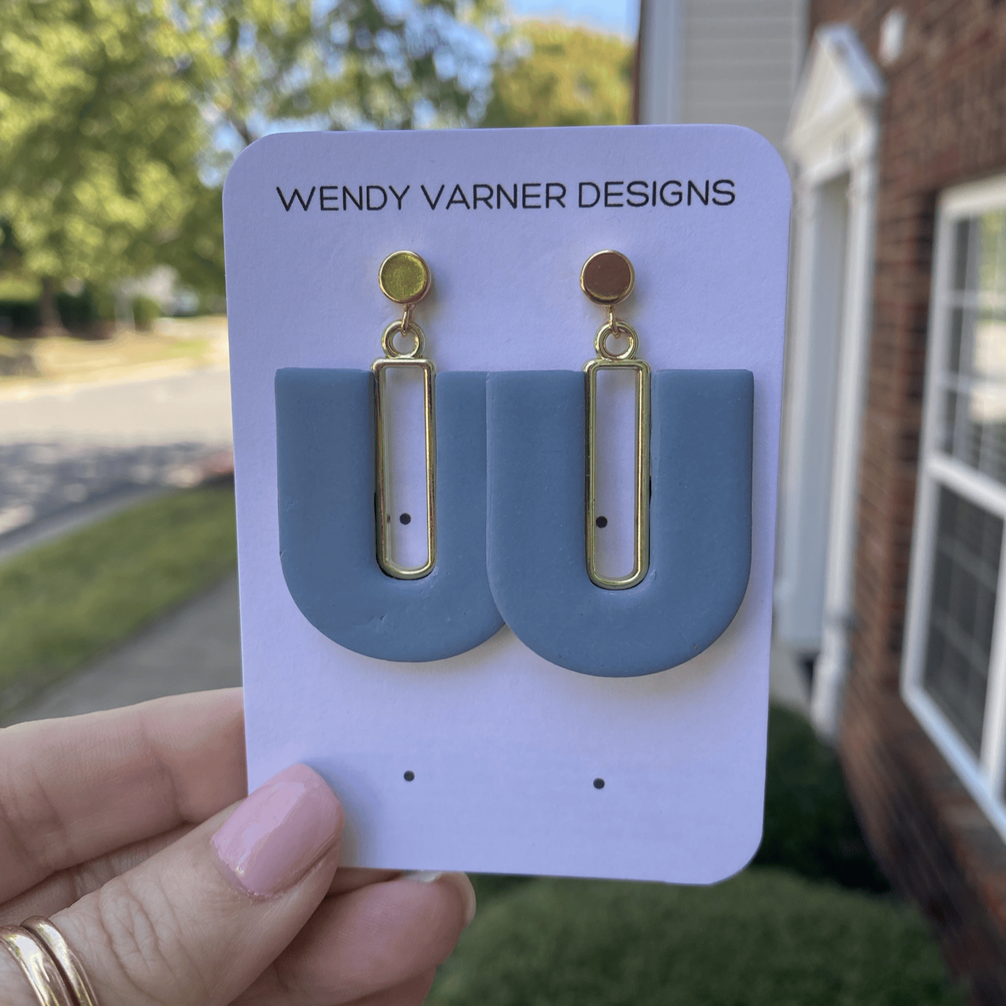 Handmade steel blue U-arch earrings with gold details in natural light