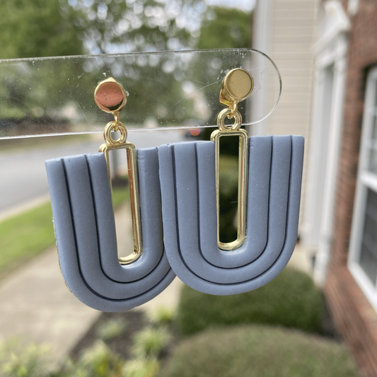 Steel blue U-arch polymer clay earrings with gold-plated open rectangle accent, handmade in Charlotte NC.