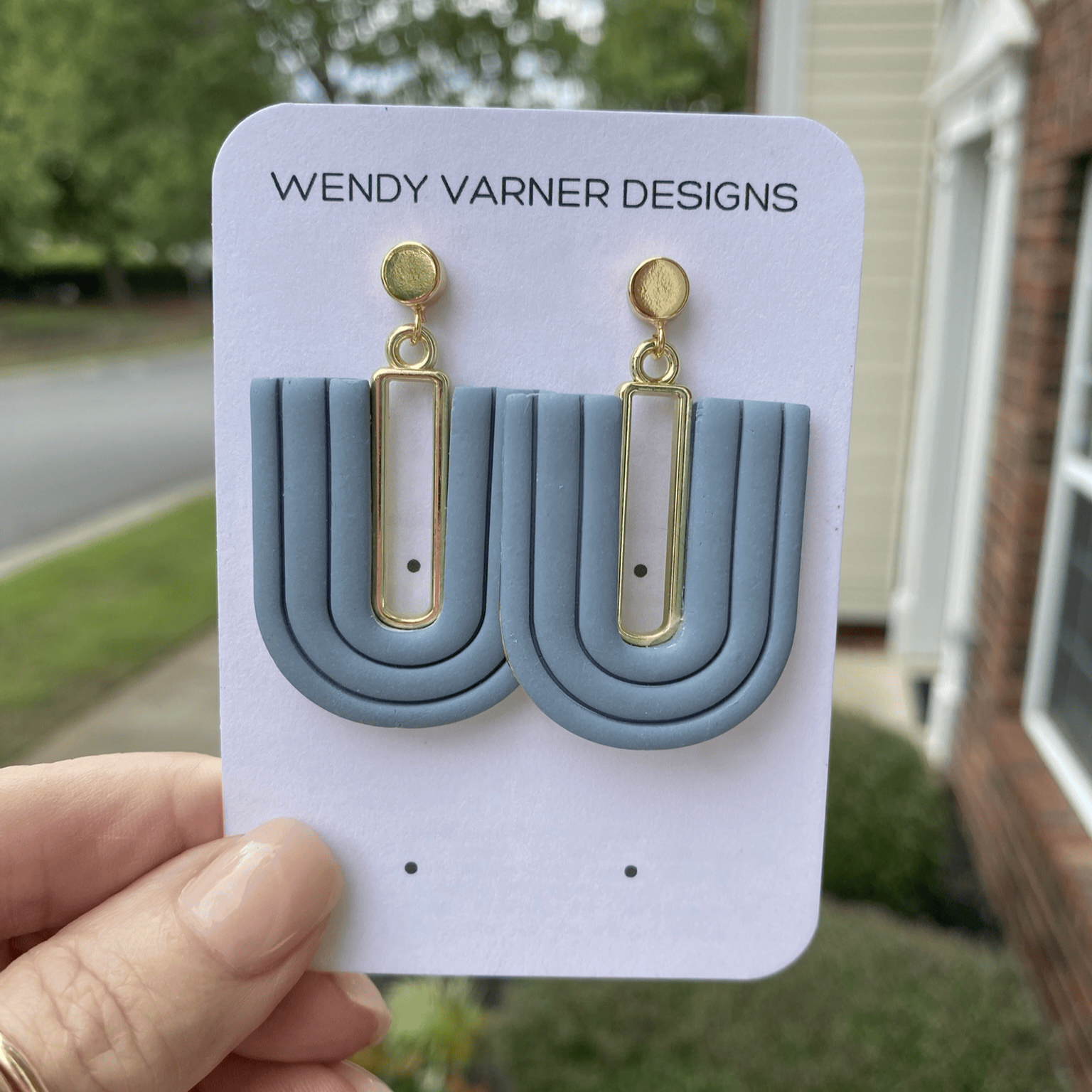 Handmade steel blue U-arch polymer clay earrings displayed on Wendy Varner Designs card.