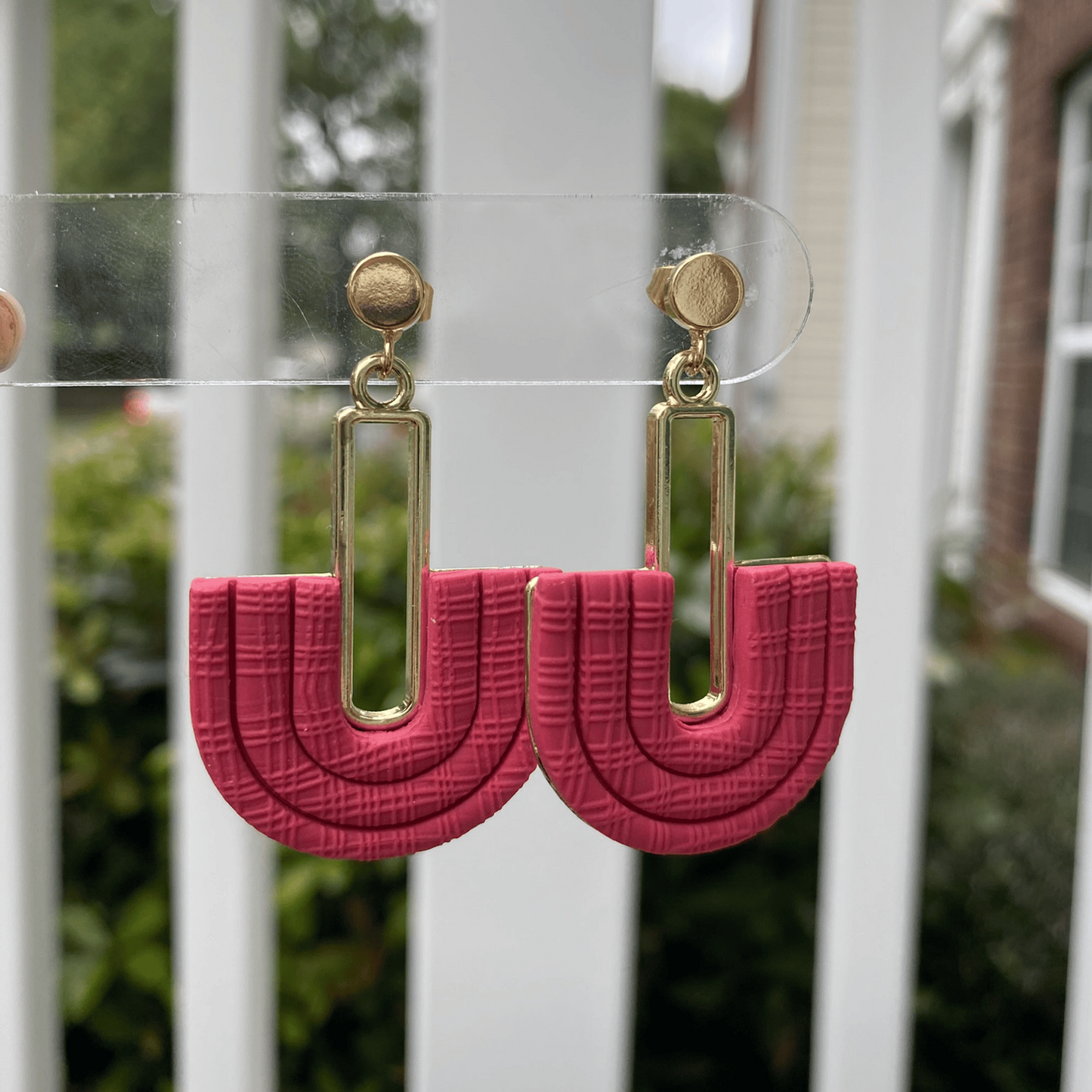 Strawberry Red half-arch polymer clay earrings with gold-plated connector on earring card – handmade in Charlotte NC.