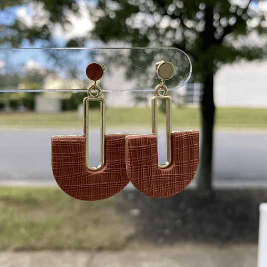Handmade terracotta arch polymer clay earrings on earring card, gold accents.